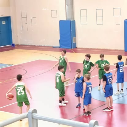 Μικρά παιδιά της Άνοιξης 78 παίζουν μπάσκετ με ομάδα σε πράσινες εμφανίσεις